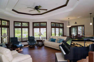 Living room with hardwood style floors, ceiling fan and large windows