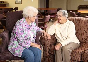 Two retired women talking on the couch