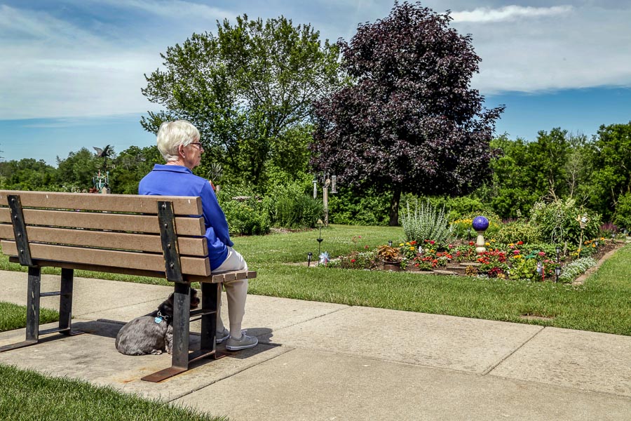 Female resident sitting on bench with her dog