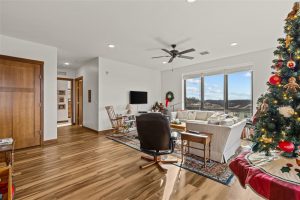 Bright open-concept living room with Christmas decor and large windows in a Cedar Crest Independent Apartment.