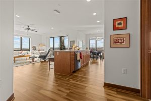 Open floor plan view of kitchen, dining, and living area with wood finishes at Cedar Crest Apartments