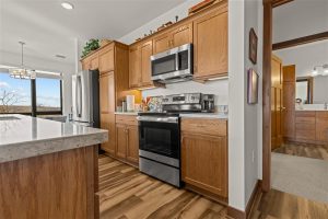 Modern kitchen with stainless steel appliances and wood cabinetry inside Cedar Crest senior apartment.