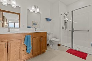 Spacious bathroom with double vanity, walk-in shower, and modern lighting at Cedar Crest Independent Living Apartment.