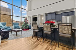 Modern lounge area at Cedar Crest Retirement Community with high ceilings, Christmas decorations, and comfortable seating near a large window