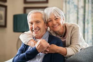 A happy senior couple warmly embracing and smiling together in their home at Cedar Crest Senior Living, a 55+ retirement community in Janesville, WI.