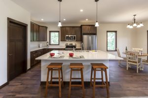 Kitchen Island with three chairs and pendant lighting